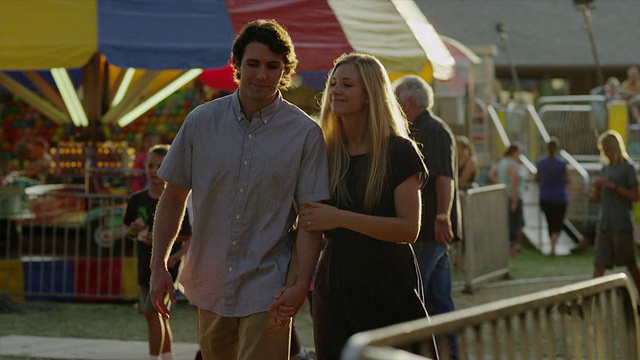 Medium shot to close up of young couple walking at carnival / American Fork, Utah, United States(美国犹他州视频素材