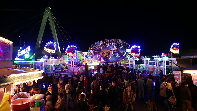 MS Shot of People enjoy amusement ride at funfair, flying bobs with People walking / Cologne，德国视频素材