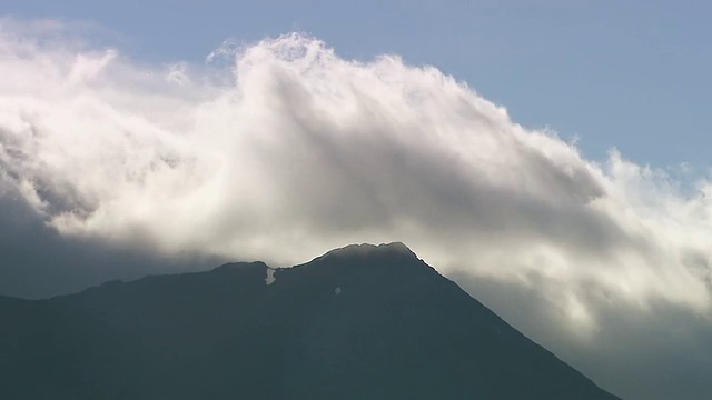 加拿大育空Kluane国家公园和保护区凯萨琳湖附近的山峰上飘过的缕缕云视频素材