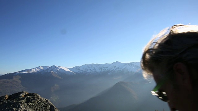 徒步旅行者爬到山顶，然后在山顶休息视频素材