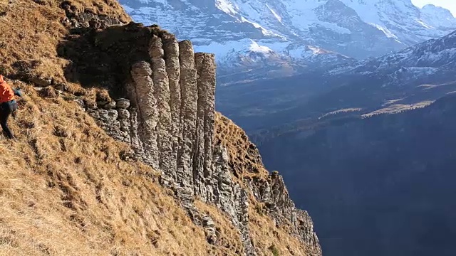 徒步旅行者攀登山谷和山脉之上的山坡视频素材