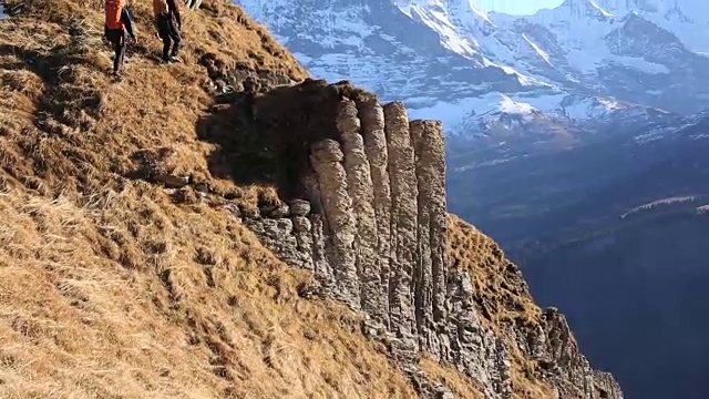 徒步旅行者爬上山谷和山脉之上的山脊视频素材