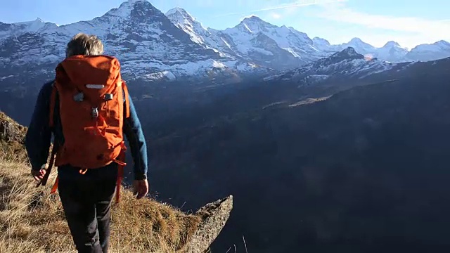 登山者站在山顶，双臂张开视频素材