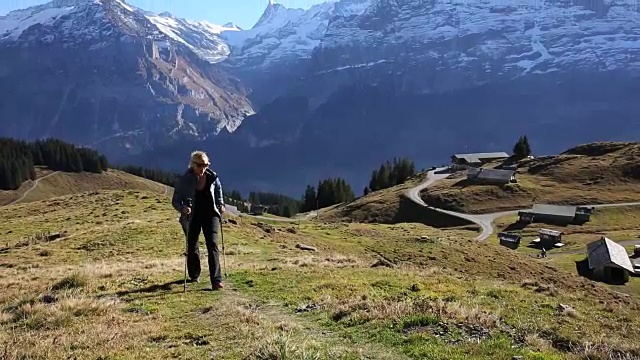 徒步旅行者爬上山谷和山脉上方的斜坡视频素材