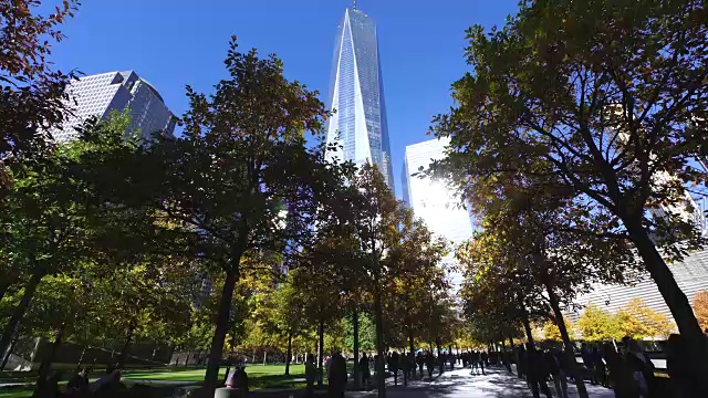 TU Camera拍摄了人们在9/11纪念大楼反射光线下走过的情景。视频素材