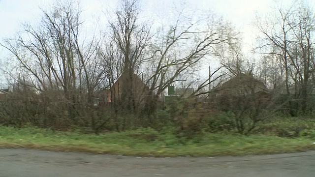 WS POV郊区住宅区的观点。街道上到处是垃圾。房屋年久失修。接着是横跨大桥，然后沿着河岸/阿尔汉格尔斯克，阿尔汉格尔斯克州，俄罗斯视频素材