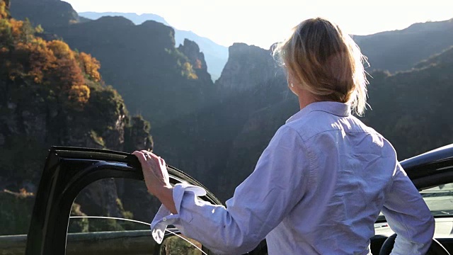 女人从车里走出来，越过峡谷望向群山视频素材