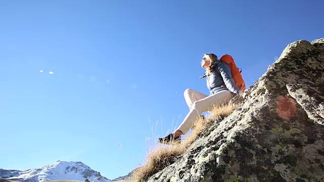 潘女徒步旅行者放松在岩石脊，高山草甸视频素材