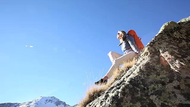 潘女徒步旅行者放松在岩石脊，高山草甸视频素材