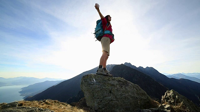 女徒步旅行者在山脊上张开双臂视频素材