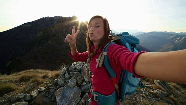 年轻的徒步旅行者在山顶上自拍视频素材