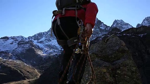 一个登山者伸展双臂，到达雪山之上的顶峰视频素材