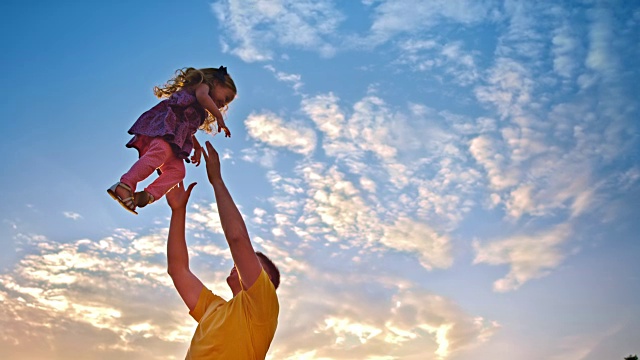 夕阳西下，爸爸把女儿抛向空中视频素材