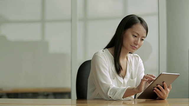 MS Business woman using a digital tablet at desk /新加坡视频素材