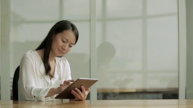 MS Business woman using a digital tablet at desk /新加坡视频素材