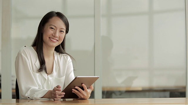 MS Business woman using a digital tablet at desk /新加坡视频素材