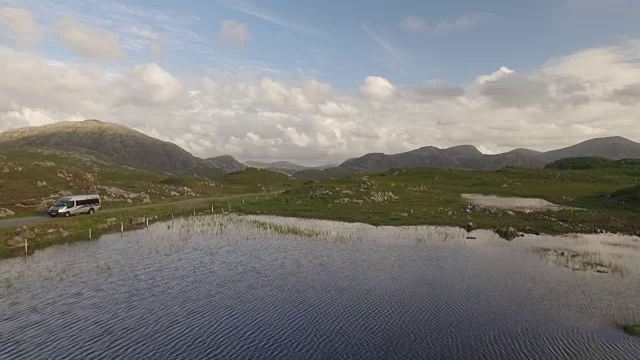 电影航拍在哈里斯岛，苏格兰附近的海岸显示山脉，一辆面包车驶过视频素材