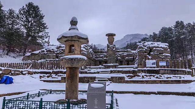 在白雪皑皑的雪景中，可以看到韩国国宝96号佛像和石灯视频素材