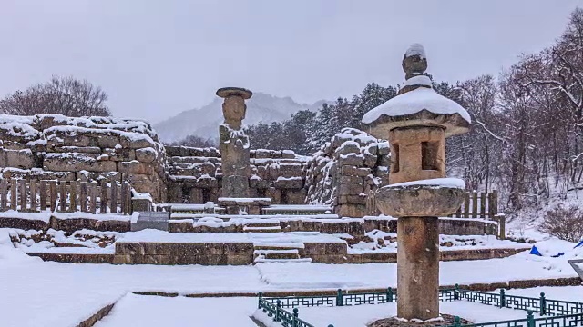 在白雪皑皑的雪景中，可以看到韩国国宝96号佛像和石灯视频素材