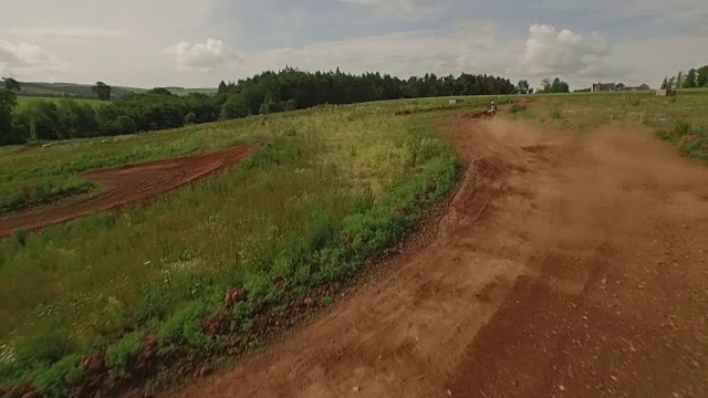 追踪无人机拍摄的四轮自行车/越野车辆在尘土飞扬的土路上视频素材