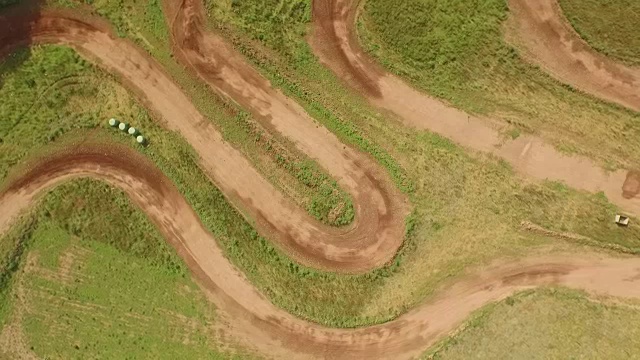 跟踪鸟瞰无人机拍摄的四轮自行车/越野车辆在尘土飞扬的土路视频素材