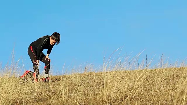 年轻女子在山上长跑后休息。视频素材