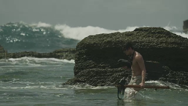 在岸边/海滩上带着鱼叉捕鱼装置的自由潜水者。视频素材