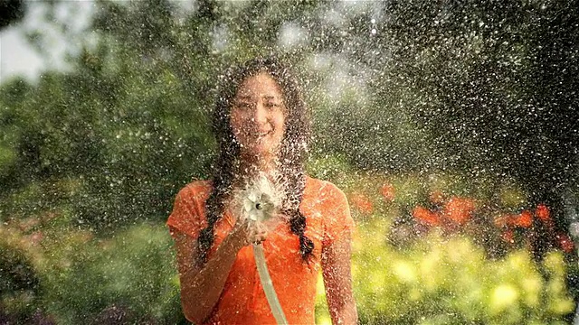 美丽的女人在花园里浇水视频素材