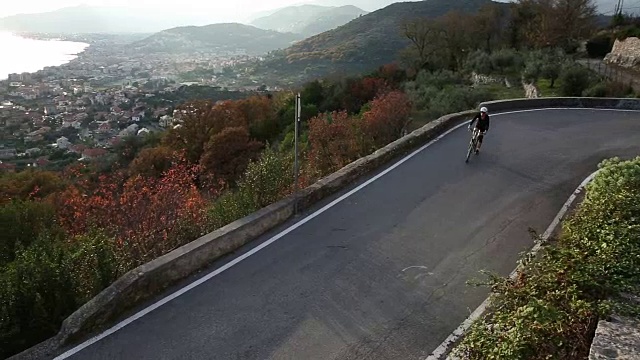 女人骑着自行车沿着山路，在海上视频素材