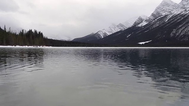 穿过冰，跳进冬季的高山湖泊视频素材