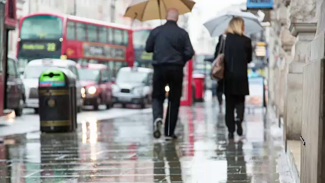 雨后的午后，皮卡迪利大街上的行人流落街头，红色电话亭、伦敦公共汽车和黑色出租车成为伦敦的标志性形象视频素材