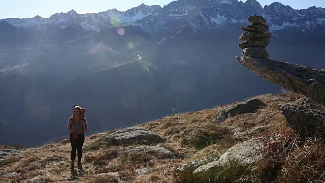 徒步者攀登山坡，经过石堆视频素材