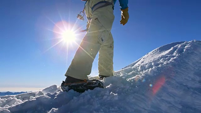 阳光下，登山运动员的双腿在山坡上行走视频素材