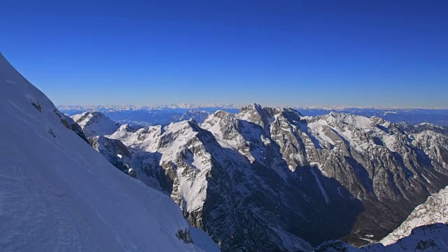 在一个阳光明媚的冬日里，两名登山运动员正在爬山视频素材