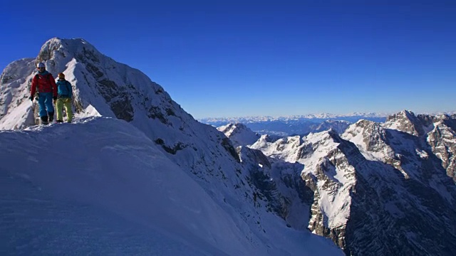 阳光下，登山队员们走下雪山脊视频素材