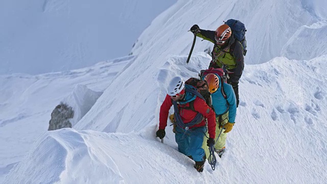 登山运动员在冬天攀登陡峭的山脊视频素材