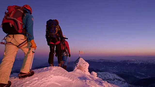 夕阳西下时，登山队员到达了白雪皑皑的山顶视频素材