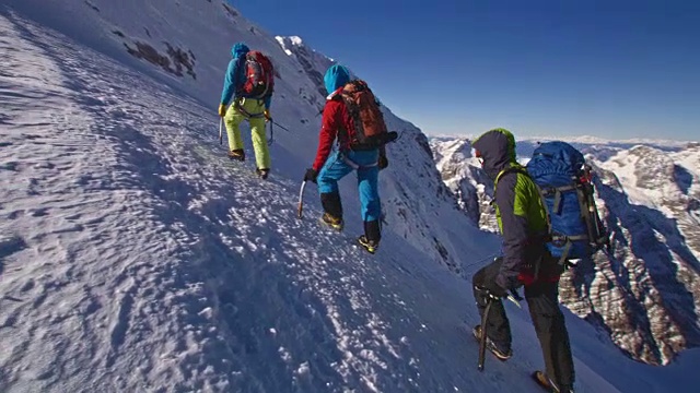 潘登山队在阳光下攀登雪山视频素材