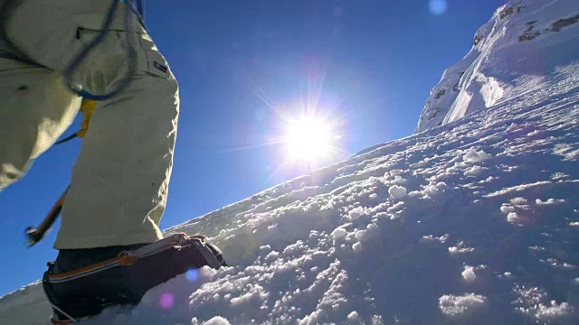 用绳子捆起来的登山运动员在阳光下爬上雪山视频素材