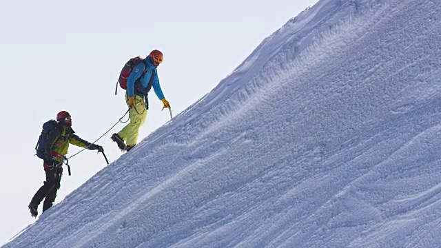 登山运动员们被一根安全绳索套住，爬上了那座多雪的山视频素材