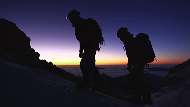 登山运动员在夜晚攀登一座雪山视频素材