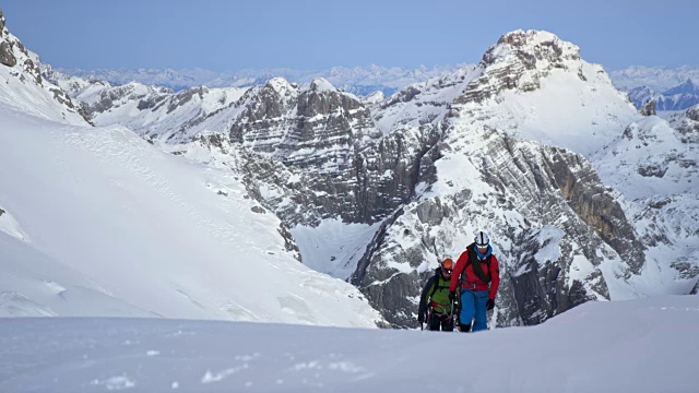 登山运动员爬上雪山的斜坡视频素材