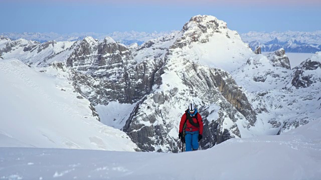 登山运动员爬上白雪覆盖的山视频素材