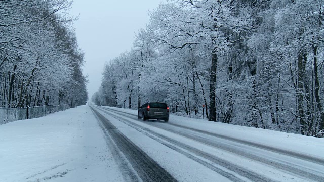 汽车在积雪下的道路上行驶视频素材