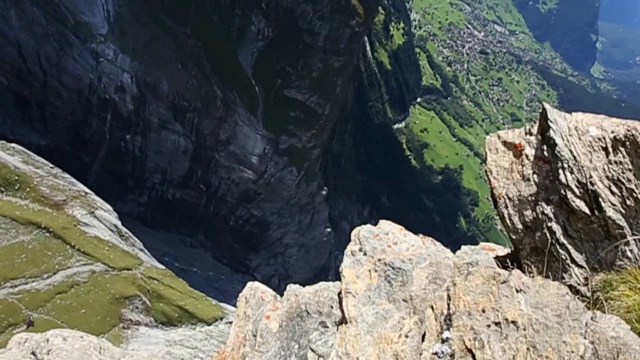 翼装飞行员从悬崖上跳下，在山谷上空翱翔视频素材