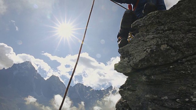 登山者在悬崖上向同伴伸出援助之手视频素材