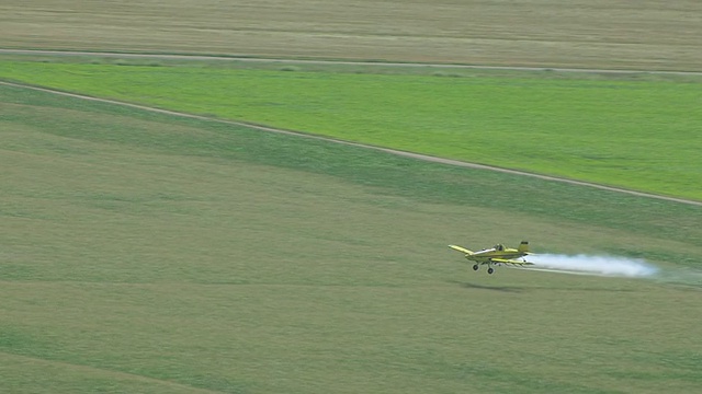 美国北达科塔州瓦普顿的黄色飞机撒农药田的MS AERIAL TS照片视频素材