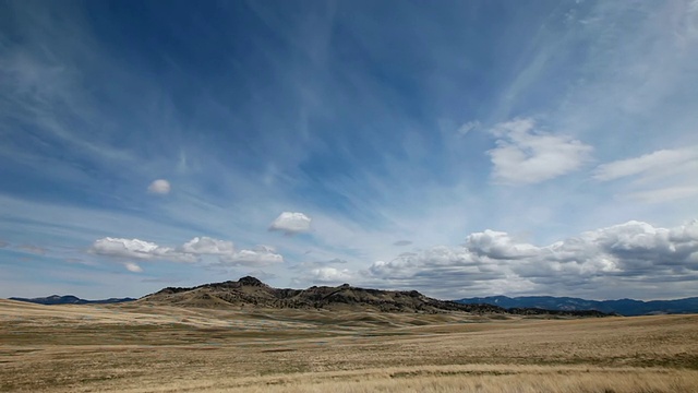 在草原上戏剧性的云与落基山脉背面和太阳和阴影滚动横跨景观/奥古斯塔，蒙大拿，美国视频素材