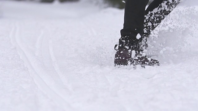 慢镜头中，一个人在雪地里奔跑，然后打滑停了下来视频素材