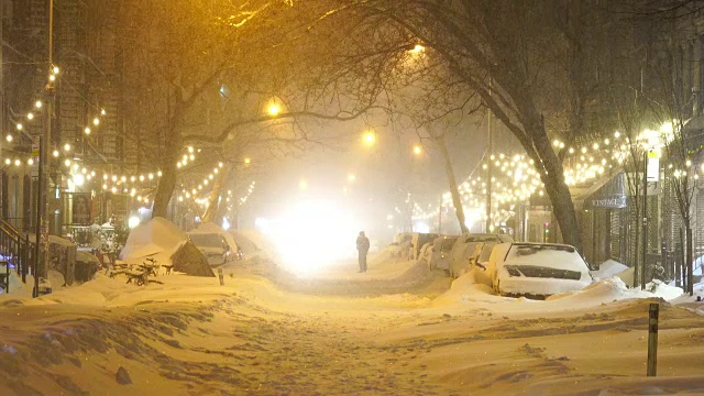 2016年1月23日晚上，严重的冬季暴风雪乔纳斯袭击了纽约东村。人们走在东村(East Village)积雪覆盖的第九大街上，这里被积雪和成排的树木包围着。视频素材